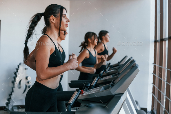 Running on a treadmill. Group of young sportive people have